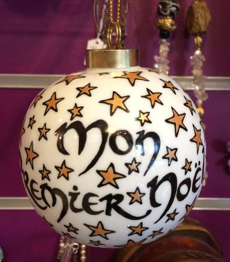 Boule de Noël en porcelaine personnalisée par des étoiles et par un prénom d'un côté et Mon premier Noël de l'autre côté.